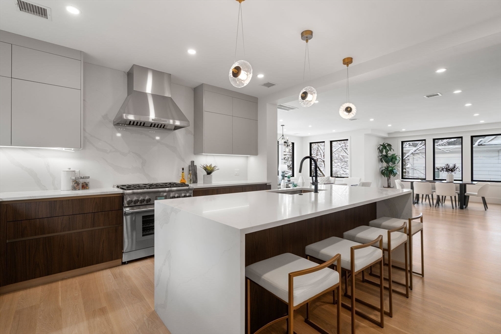 116 Thorndike Street, Unit 2B Brookline, MA 02446 - Photo 17 of 33 a kitchen with stainless steel appliances granite countertop a sink a stove and chairs