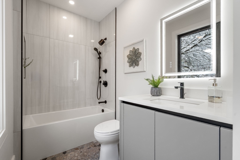 116 Thorndike Street, Unit 2B Brookline, MA 02446 - Photo 22 of 33 a bathroom with a granite countertop sink a toilet and shower