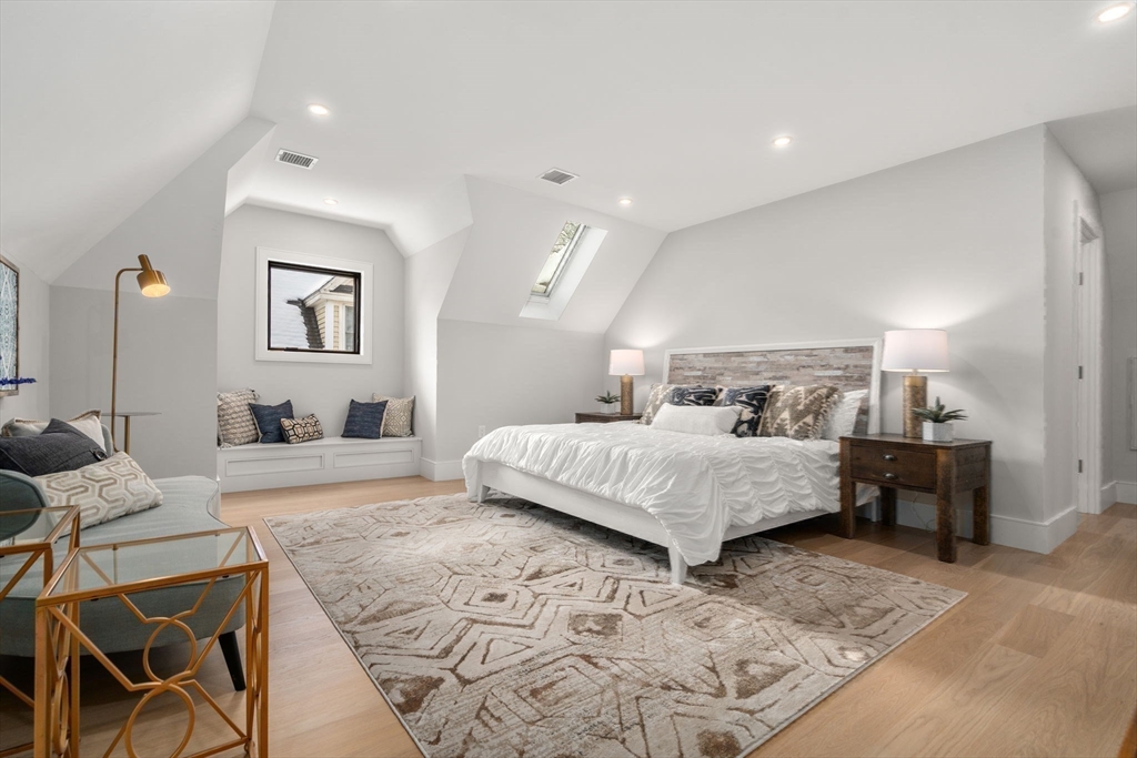 116 Thorndike Street, Unit 2B Brookline, MA 02446 - Photo 23 of 33 a spacious bedroom with a bed a table and chair