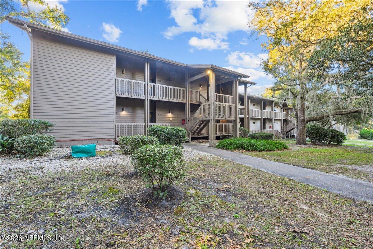 a view of a brick house next to a yard with potted plants