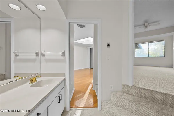 a bathroom with a tub sink and mirror