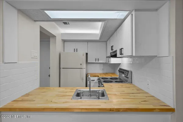 a kitchen with kitchen island sink refrigerator and stove