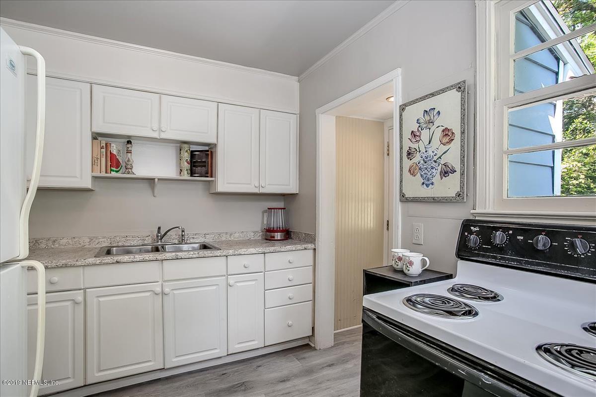 1742 Planters Road Jacksonville, FL 32207 - Photo 8 of 18 a kitchen with stainless steel appliances white cabinets and a stove top oven