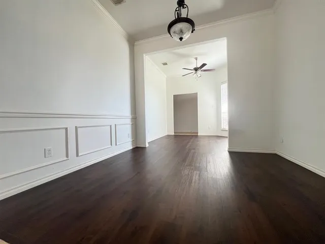 a view of a room with wooden floor and ceiling fan