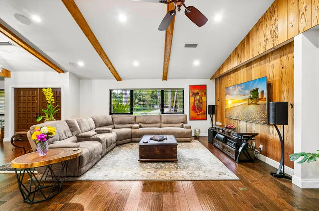 a living room with stainless steel appliances kitchen island granite countertop furniture and wooden floor