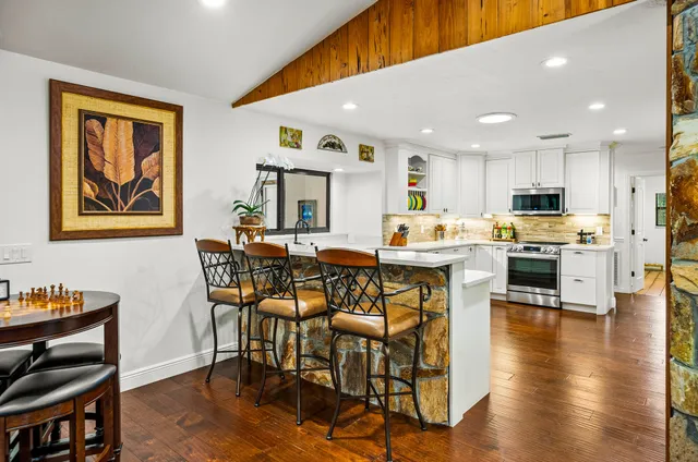 a view of a kitchen with a sink and dishwasher refrigerator with wooden floor