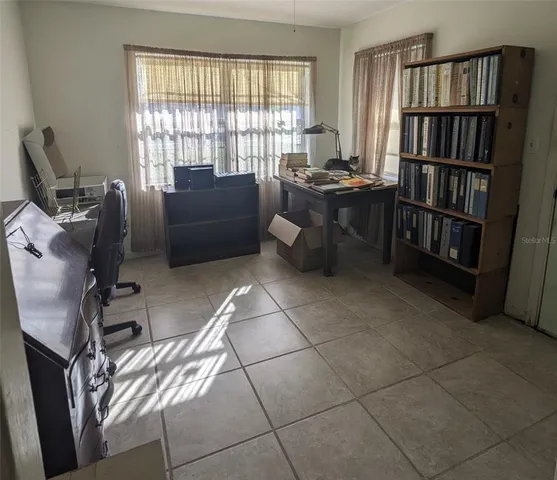 a view of a workspace with furniture and a bookshelf