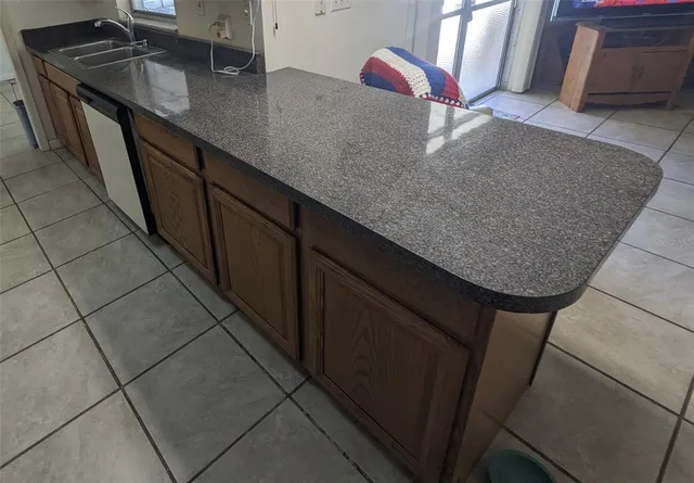 a kitchen with granite countertop a sink a stove and cabinets