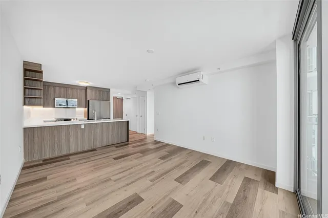 a view of a kitchen with wooden floor and electronic appliances