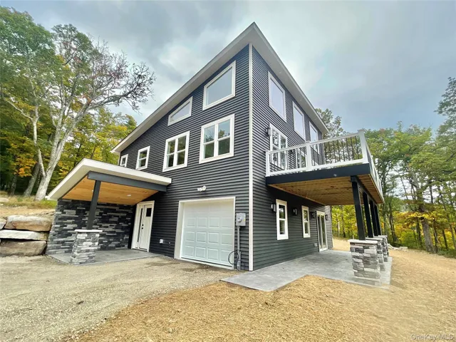 a view of a house with a patio and a yard