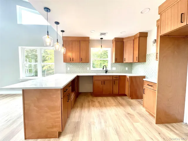 a kitchen with stainless steel appliances kitchen island wooden cabinets a sink and a window