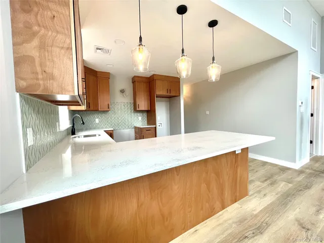 a kitchen with kitchen island a sink and a wooden floor