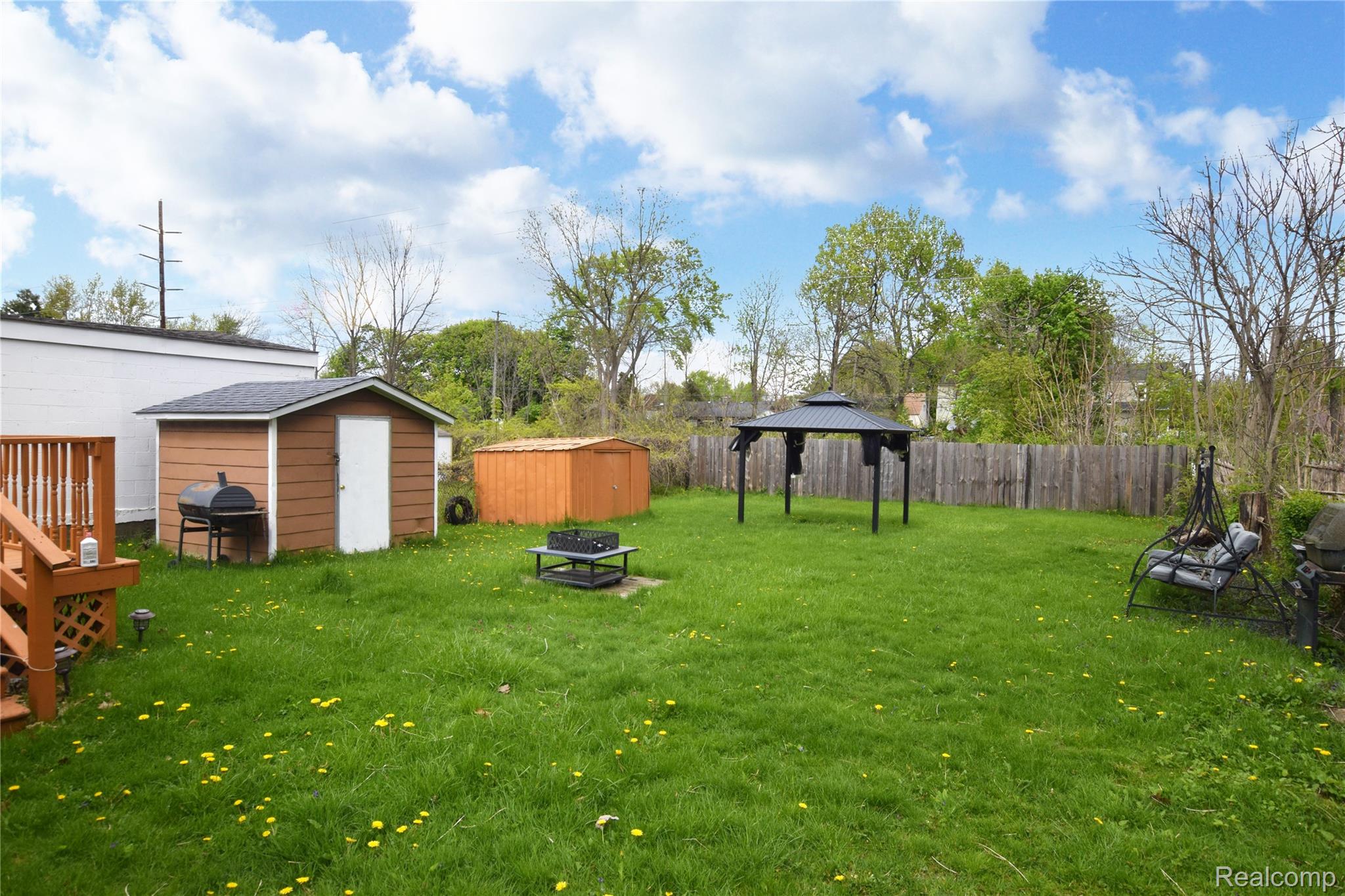 4301 Pengelly Road Flint, MI 48507 - Photo 14 of 16 Fenced yard featuring a storage unit, an outdoor fire pit, and a gazebo
