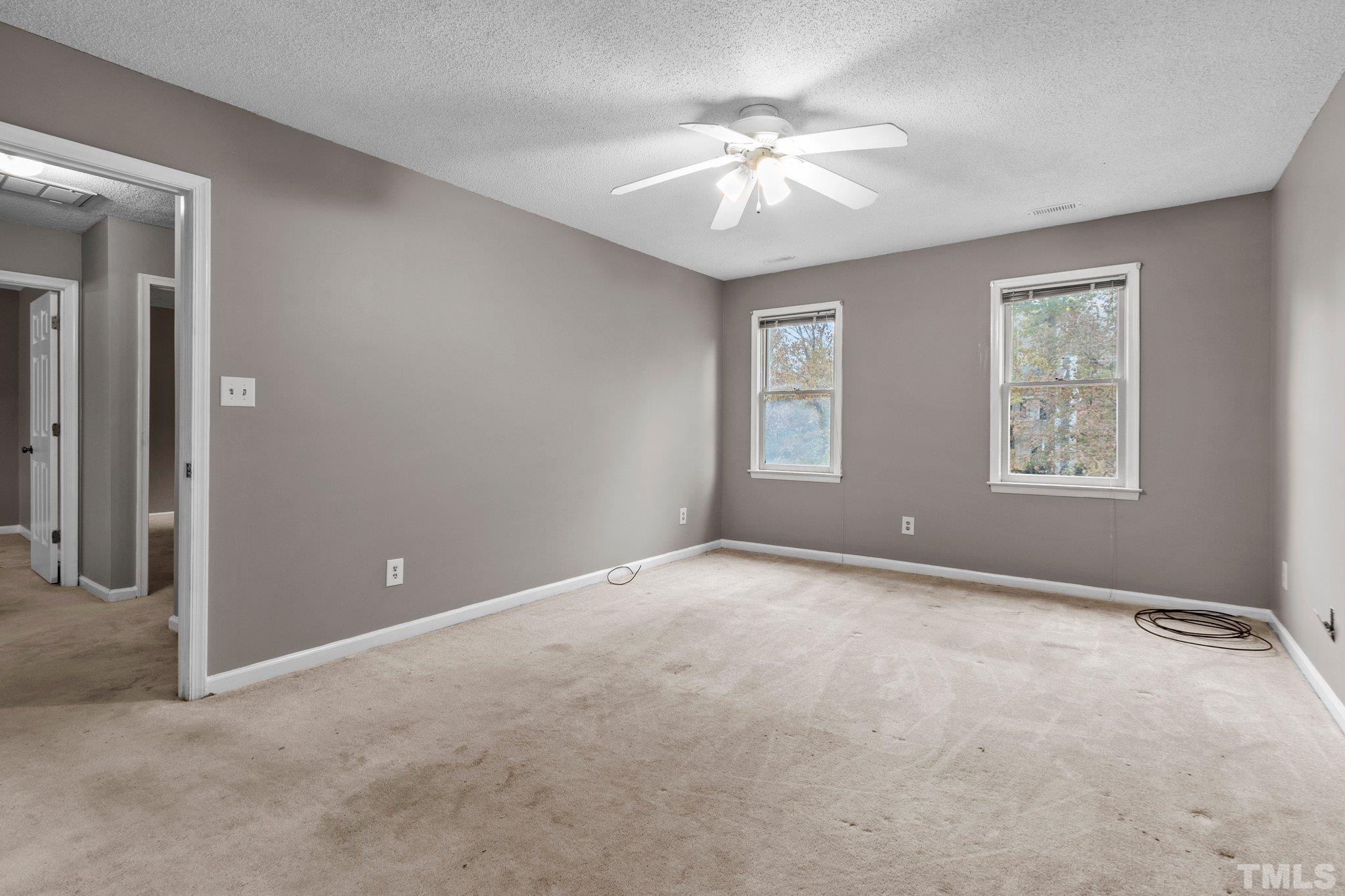 1305 Logan Street Durham, NC 27704 - Photo 11 of 32 an empty room with windows and chandelier fan