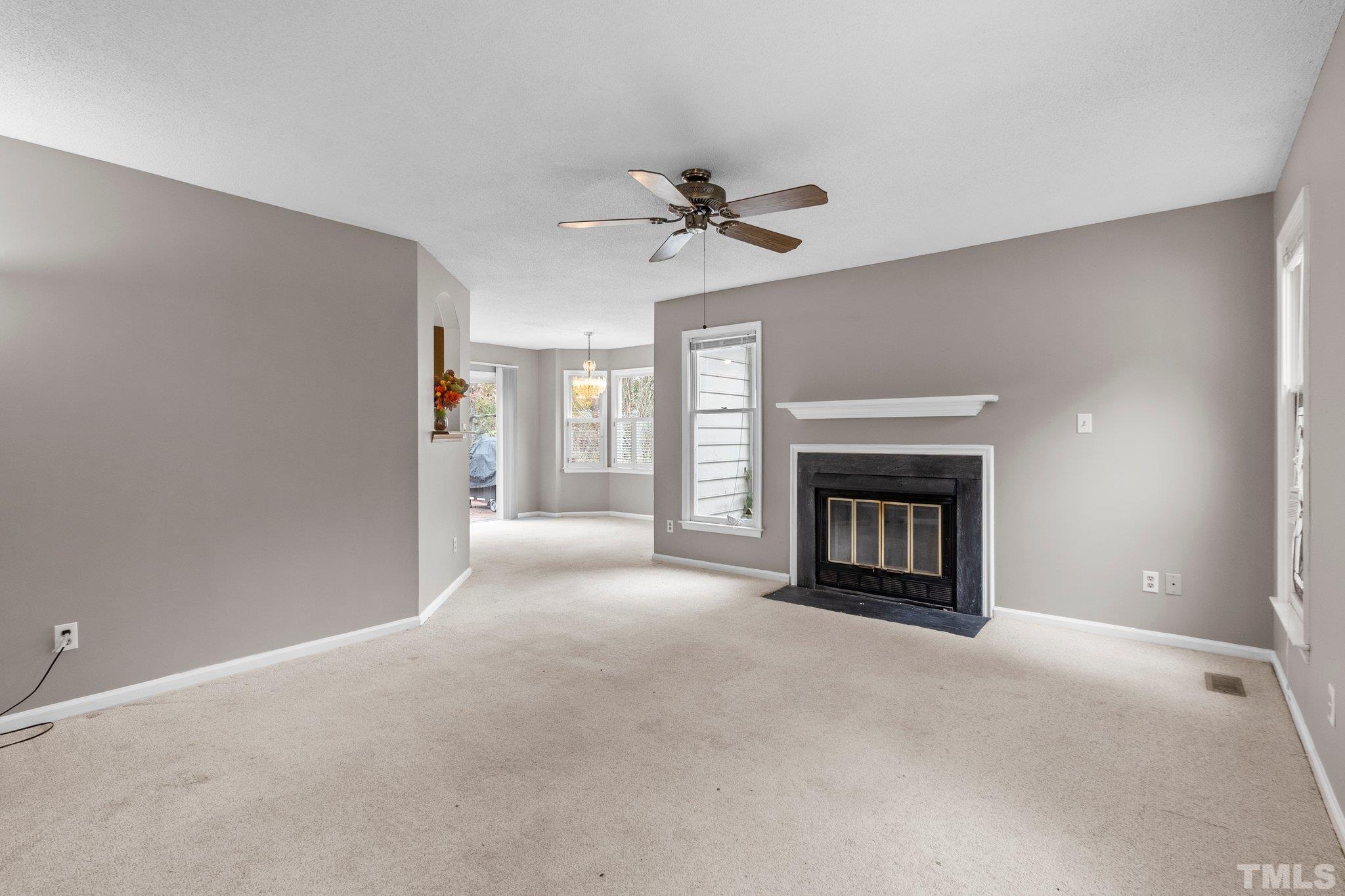 1305 Logan Street Durham, NC 27704 - Photo 2 of 32 a view of a livingroom with a fireplace and a ceiling fan