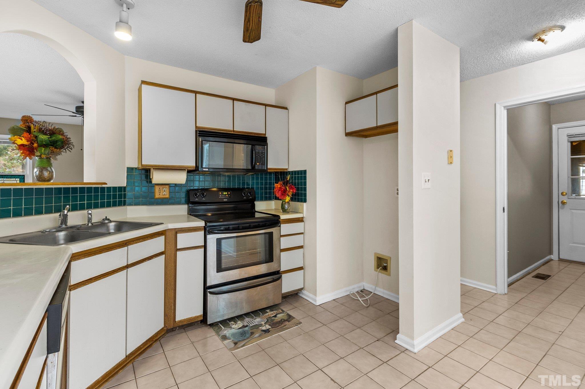 1305 Logan Street Durham, NC 27704 - Photo 6 of 32 a kitchen with a stove a sink and a refrigerator