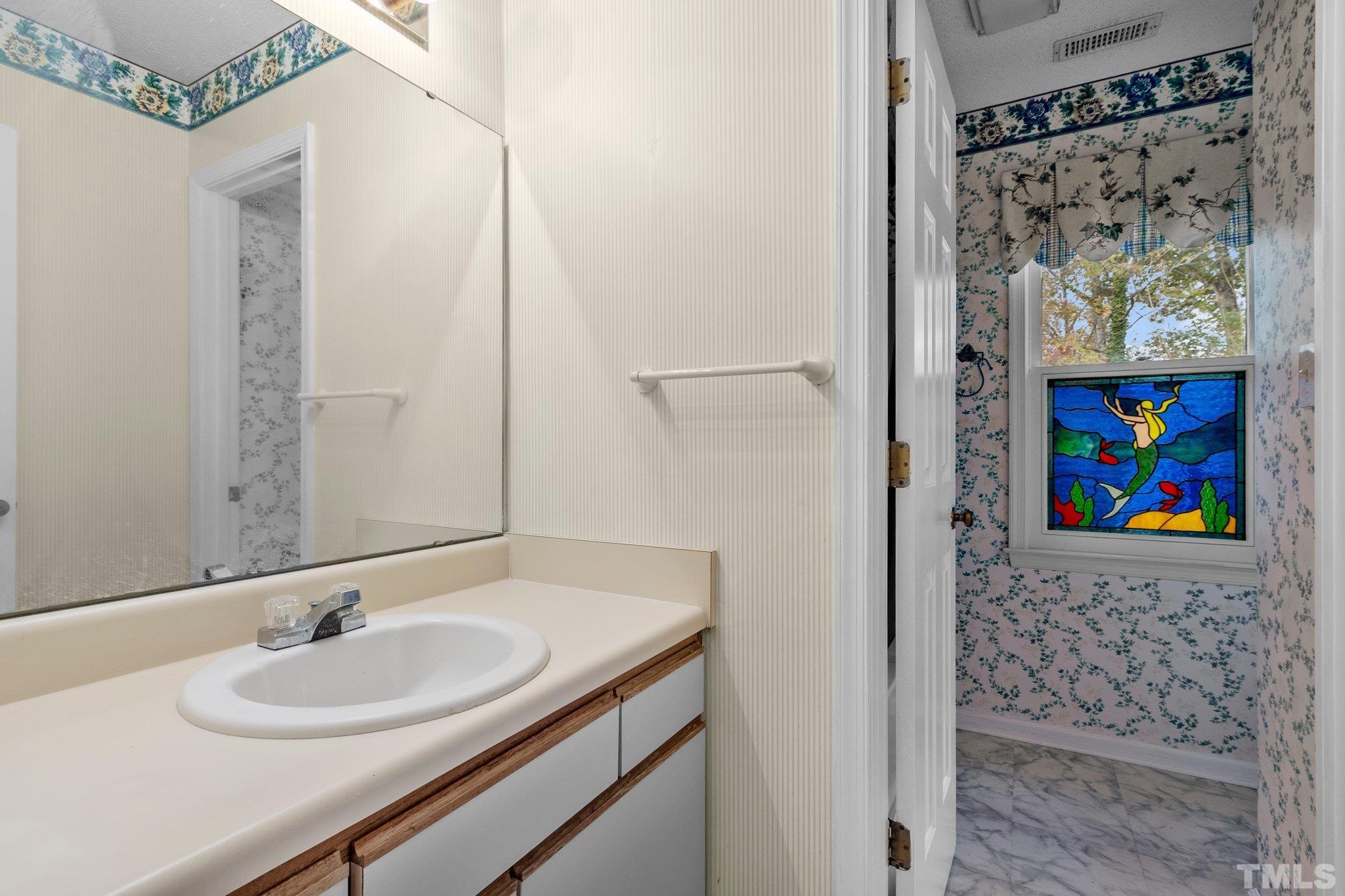 1305 Logan Street Durham, NC 27704 - Photo 9 of 32 a bathroom with a sink and a mirror