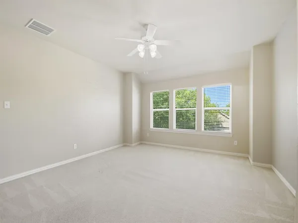 a view of an empty room with a ceiling fan