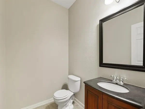 a bathroom with a granite countertop sink toilet and mirror