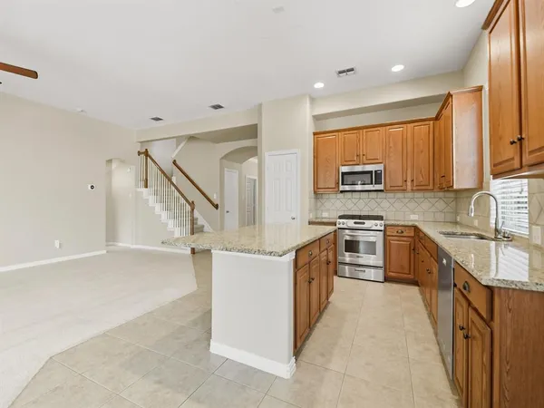 a kitchen with stainless steel appliances granite countertop a sink stove and cabinets