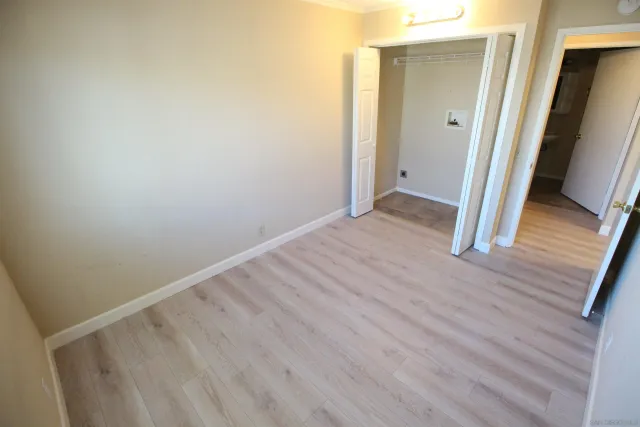 an empty room with wooden floor and sliding door
