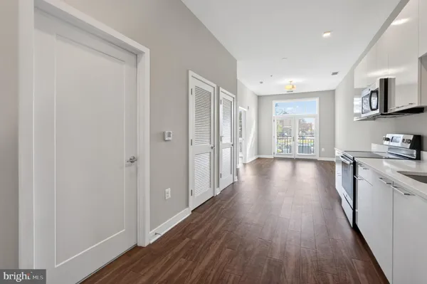 a view of a kitchen with a stove top oven a refrigerator with wooden floor