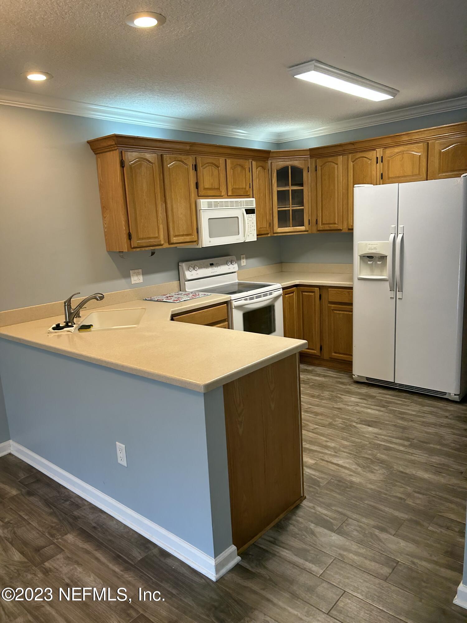 3801 Crown Point Road, Unit 1021 Jacksonville, FL 32257 - Photo 2 of 8 a kitchen with stainless steel appliances a stove a refrigerator a sink and a refrigerator