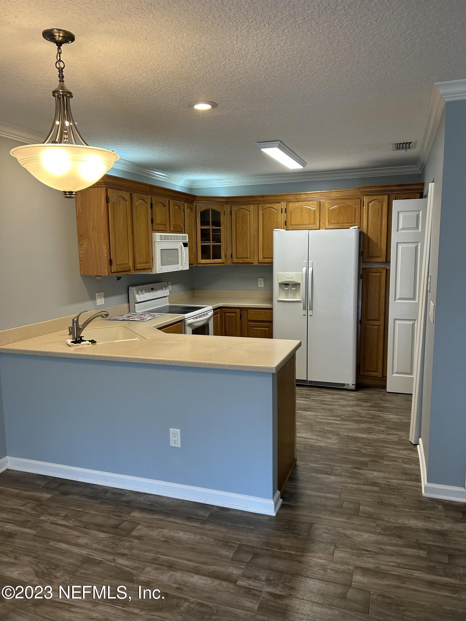 3801 Crown Point Road, Unit 1021 Jacksonville, FL 32257 - Photo 3 of 8 a kitchen with stainless steel appliances granite countertop a stove a sink and a refrigerator