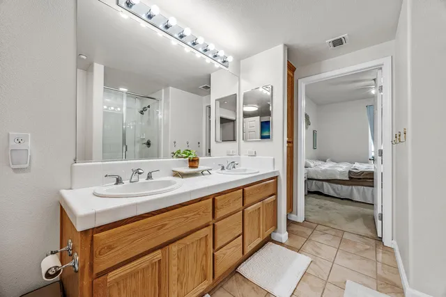 a en suite bathroom with a double vanity sink and a mirror