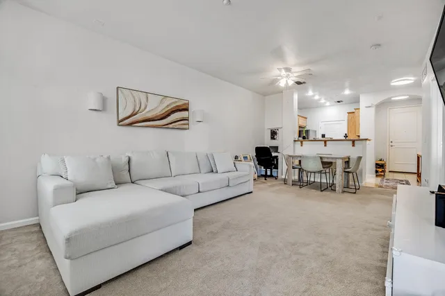 a living room with furniture and kitchen view