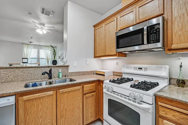 a kitchen with stainless steel appliances granite countertop a sink stove and microwave