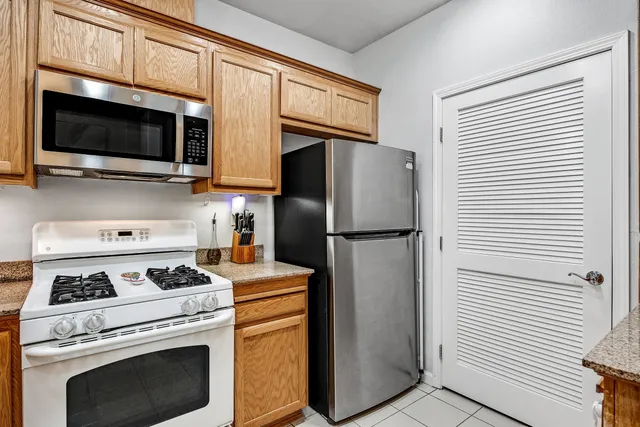 a kitchen with stainless steel appliances a stove microwave and refrigerator
