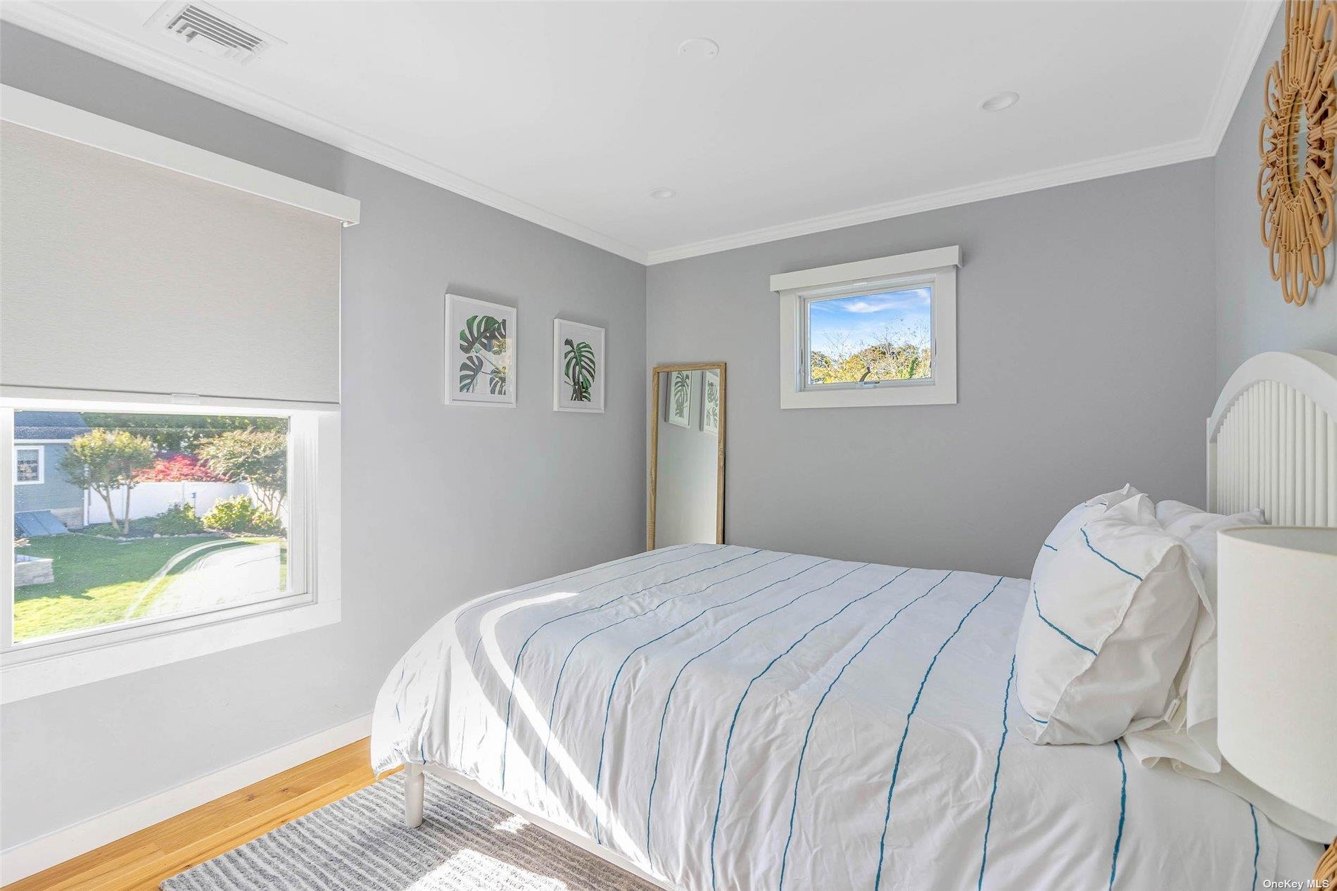 155 Bridge Street Greenport, NY 11944 - Photo 15 of 30 a bedroom with a bed and a window