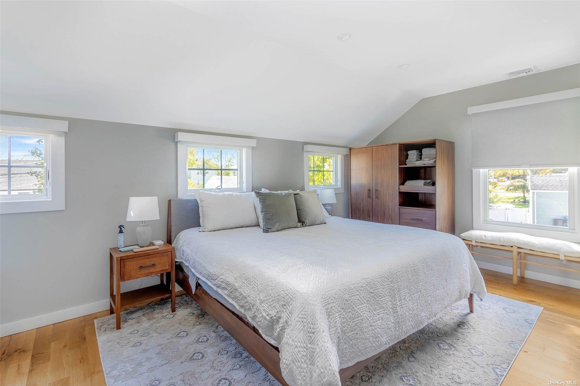 155 Bridge Street Greenport, NY 11944 - Photo 18 of 30 a bedroom with a bed and a large window