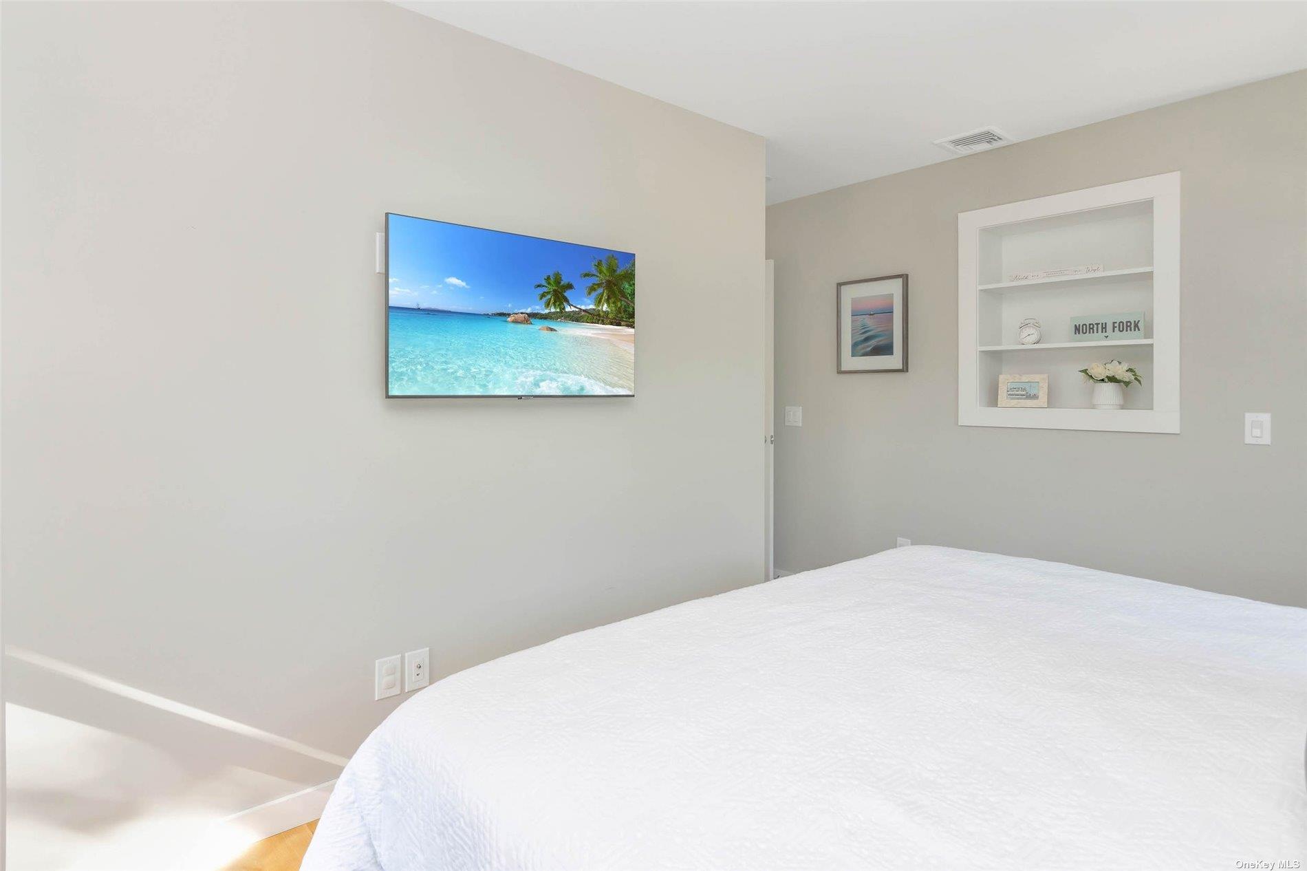 155 Bridge Street Greenport, NY 11944 - Photo 19 of 30 a bedroom with a bed and a painting on the wall