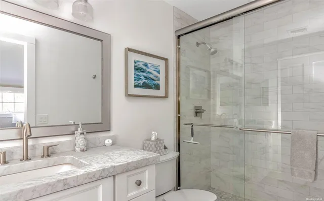a bathroom with a granite countertop sink toilet and shower