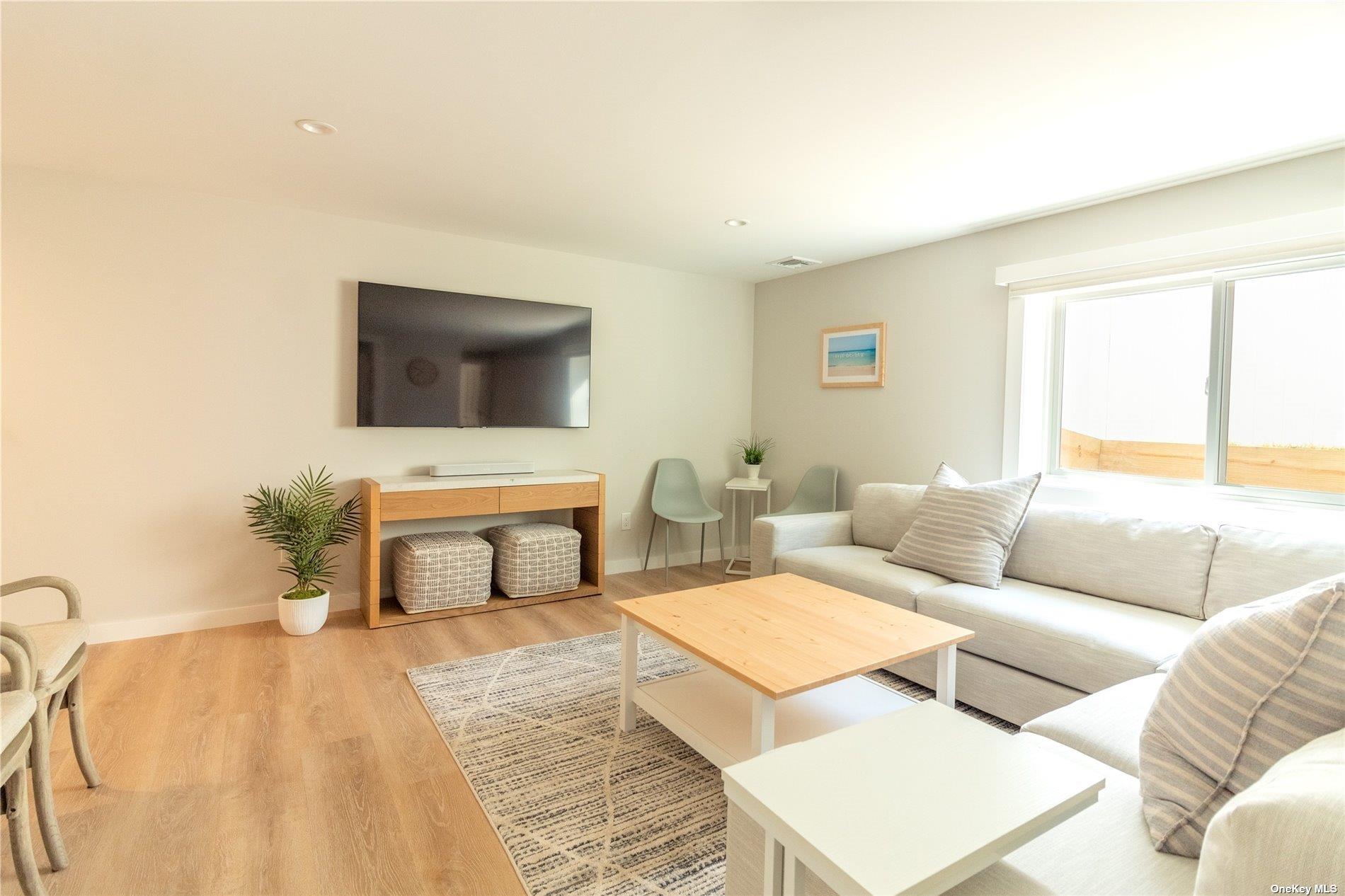 155 Bridge Street Greenport, NY 11944 - Photo 22 of 30 a living room with furniture and a flat screen tv