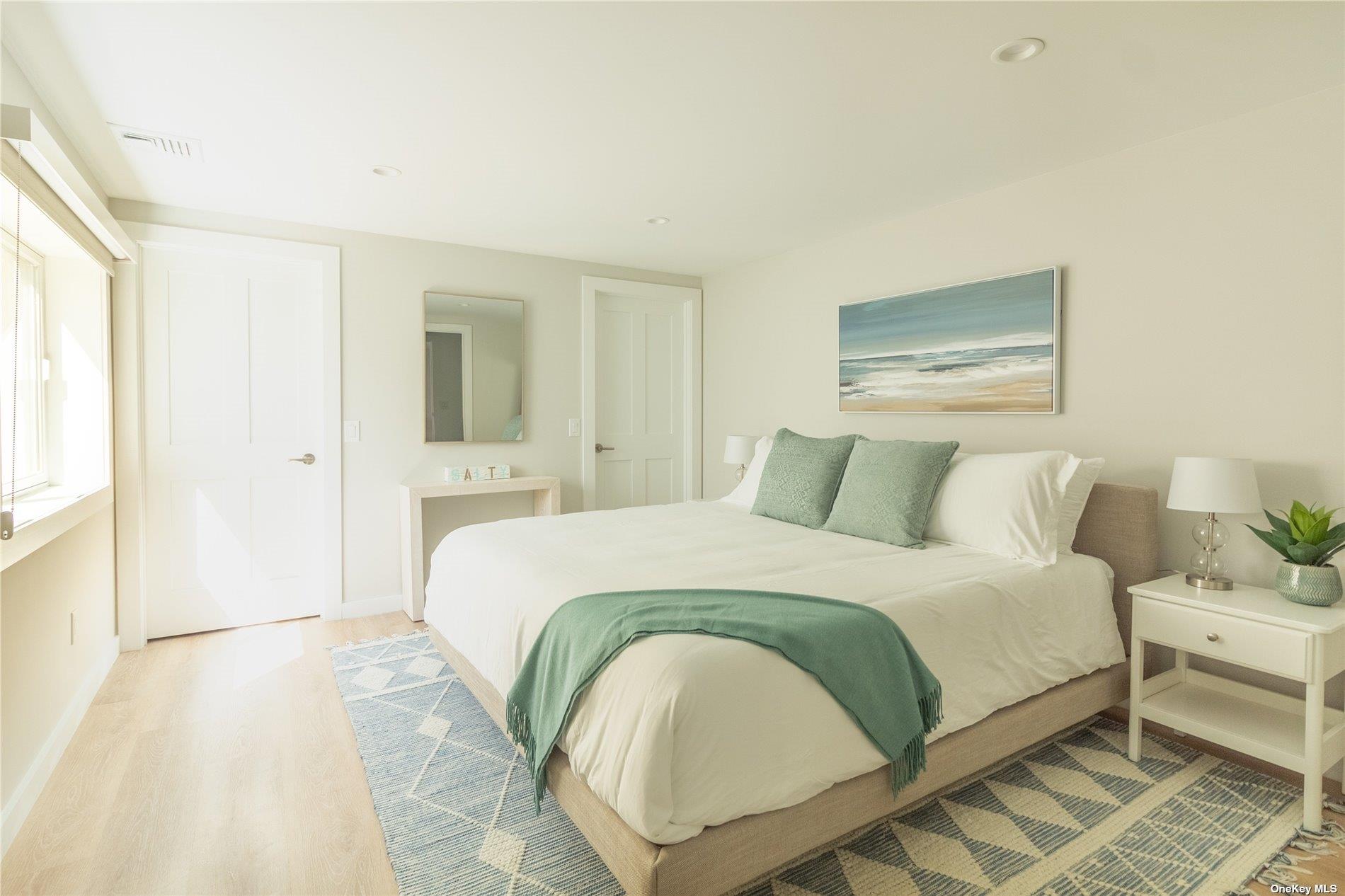 155 Bridge Street Greenport, NY 11944 - Photo 24 of 30 a bedroom with a bed and a painting on the wall