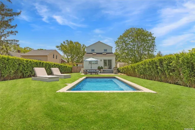 a view of a house with a swimming pool and a yard