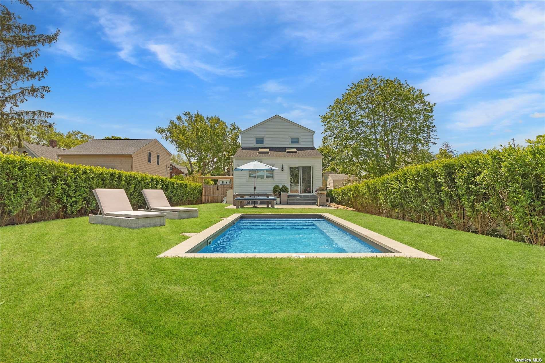 155 Bridge Street Greenport, NY 11944 - Photo 30 of 30 a view of a house with a swimming pool and a yard