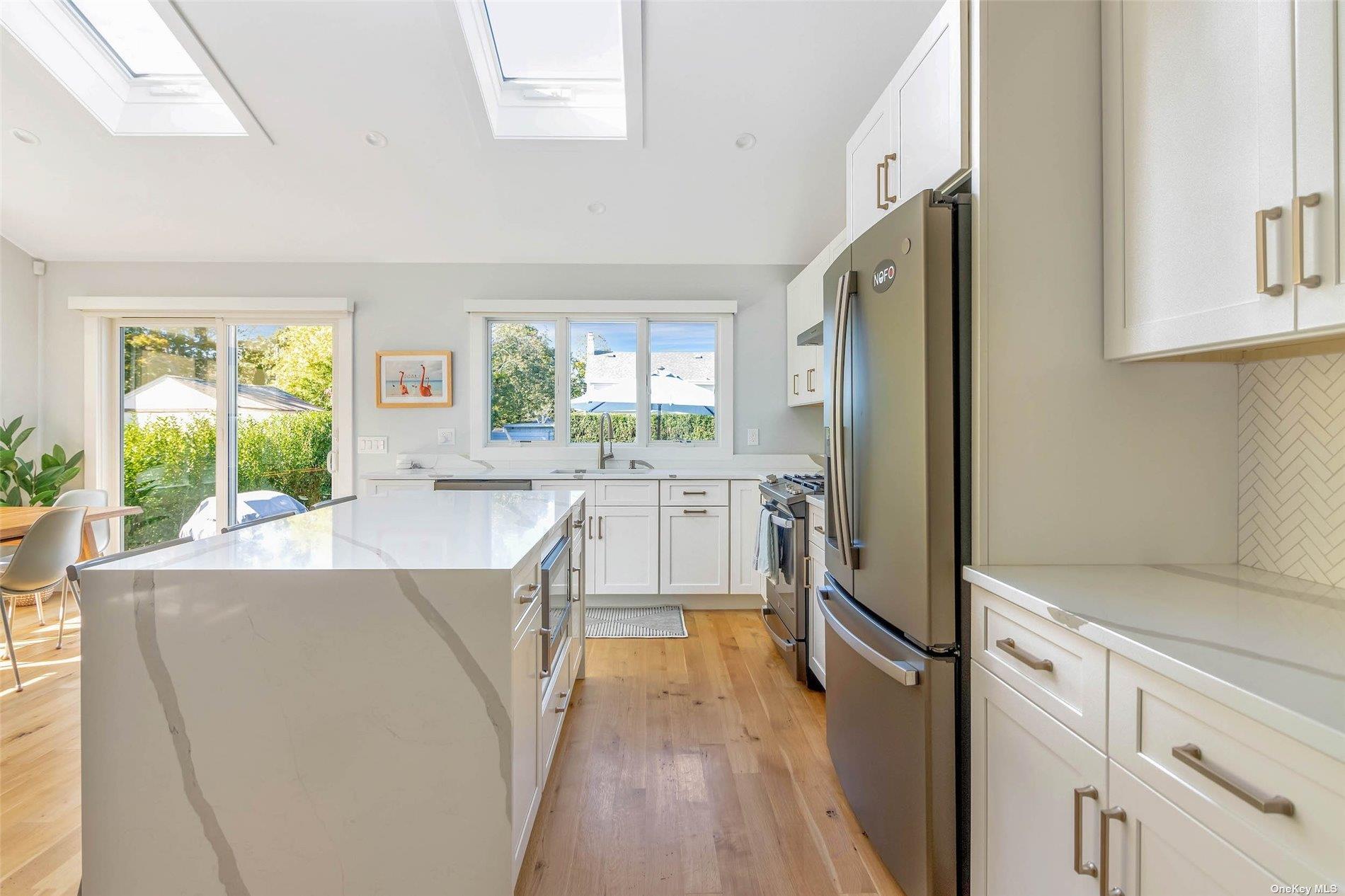 155 Bridge Street Greenport, NY 11944 - Photo 9 of 30 a kitchen with stainless steel appliances a refrigerator sink and cabinets