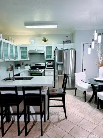 a kitchen with stainless steel appliances a table chairs and a refrigerator