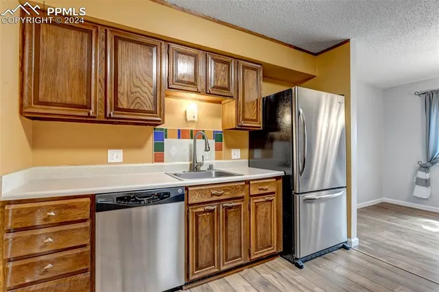 a kitchen with granite countertop stainless steel appliances and wooden cabinets