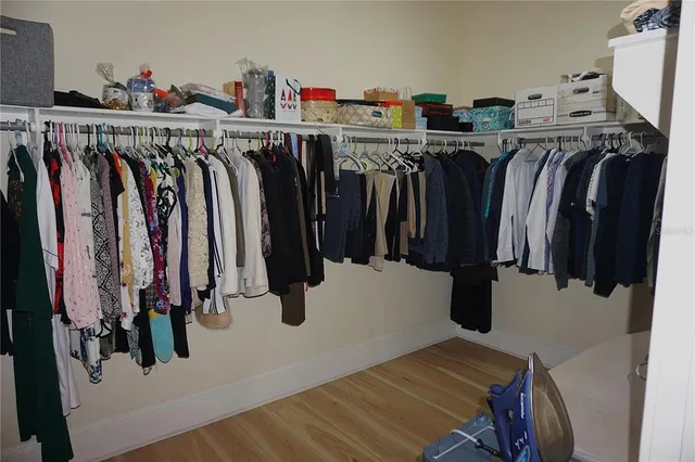 a view of walk in closet with clothes and shoes