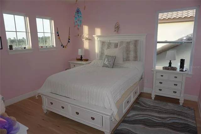 a spacious bedroom with a bed and a dresser in it