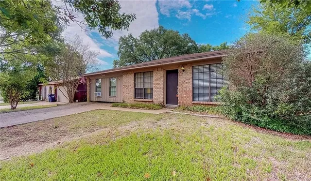 a view of a yard in front of a house with large tree