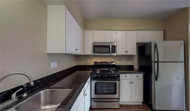 a kitchen with a refrigerator stove and sink