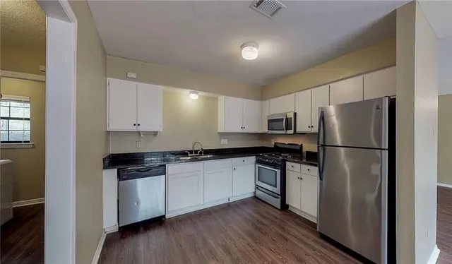 a kitchen with stainless steel appliances a refrigerator sink and cabinets