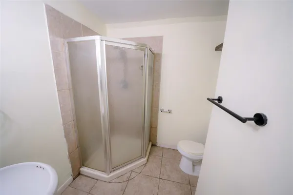 a bathroom with a granite countertop shower and a toilet
