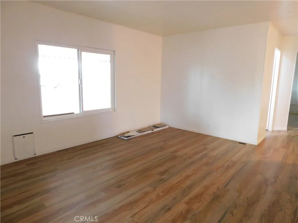 5700 West Wilson Street, Unit 1 Banning, CA 92220 - Photo 14 of 49 an empty room with wooden floor and windows